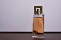Stylish close-up of a transparent glass perfume bottle on a wooden surface.